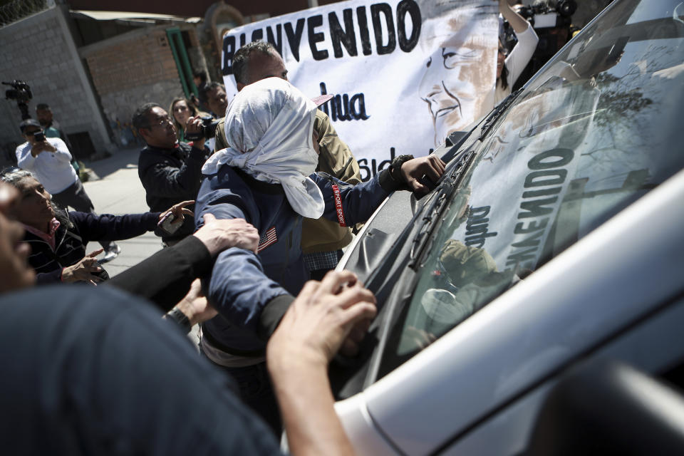 Migrantes y activistas intentan detener un vehículo en el que viaja el presidente mexicano Andrés Manuel López Obrador el viernes 31 de marzo de 2023, cuando visitaba Ciudad Juárez, en México. (AP Foto/Christian Chávez)