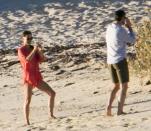 The lovebirds larked around on the beach taking photos of each other.