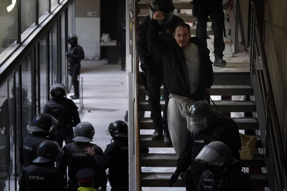 Rap singer Pablo Hasél is detained by police officers at the University of Lleida, Spain, Tuesday, Feb. 16, 2021. A 24-hour standoff between police and a rapper barricaded with dozens of his supporters in a university ended with the arrest of the artist, who has been sentenced to 9 months in prison for insulting the monarchy and praising terrorism. (AP Photo/Joan Mateu)