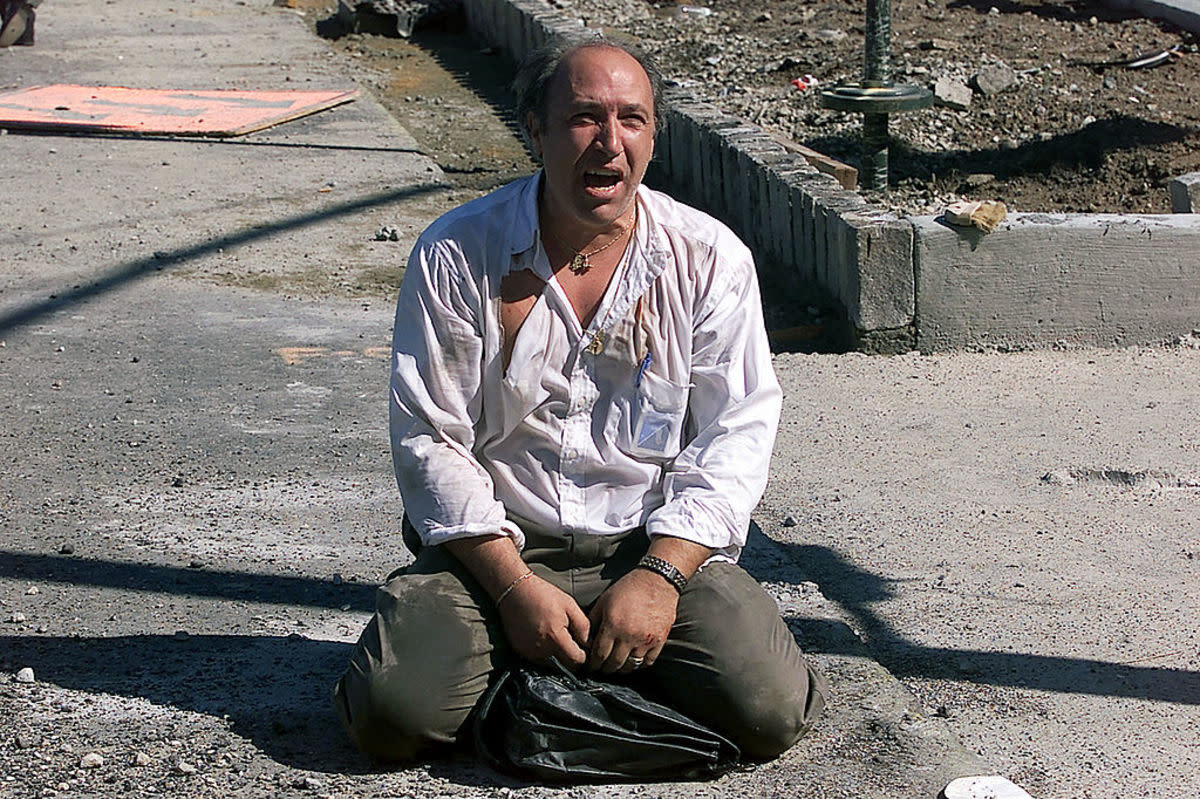 <p>Photo by Jose Jimenez/Primera Hora/Getty Images</p><p>A survivor sits outside the World Trade Center after two planes hit the building on September 11, 2001, in New York City. </p>