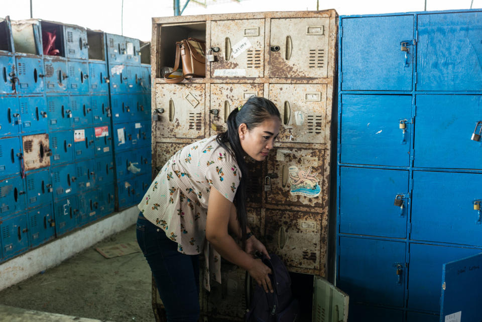 Istiyaroh, 35, an employee at Kaho Indah Citra Garment factory in North Jakarta, collects her bag from a locker when she finishes her shift. (Photo: Elisabetta Zavoli for HuffPost)
