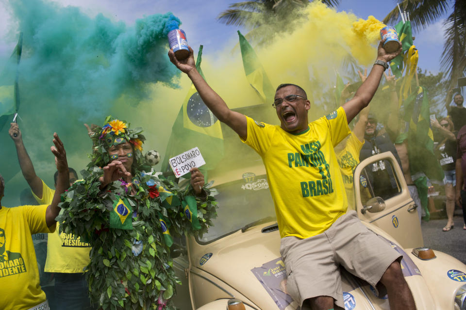 Supporters of presidential front-runner Jair Bolsonaro sing the national anthem outside his residence in Rio de Janeiro, Brazil, Sunday, Oct. 28, 2018, during the country's presidential runoff election. Brazilian voters decide who will next lead the world's fifth-largest country, the left-leaning Fernando Haddad of the Workers' Party, or far-right rival Jair Bolsonaro of the Social Liberal Party. (AP Photo/Silvia Izquierdo)