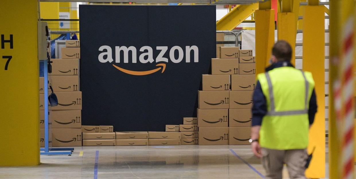 an amazon employee passes by its logo on the opening day of the new distribution center in augny, eastern france, on september 23, 2021