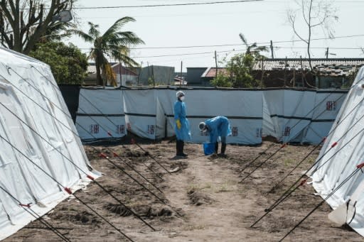 Medical staff disinfect themselves beside treatment tents at Macurungo, where one senior official warned more beds were urgently needed while doctors and nurses said they fear the worst is yet to come