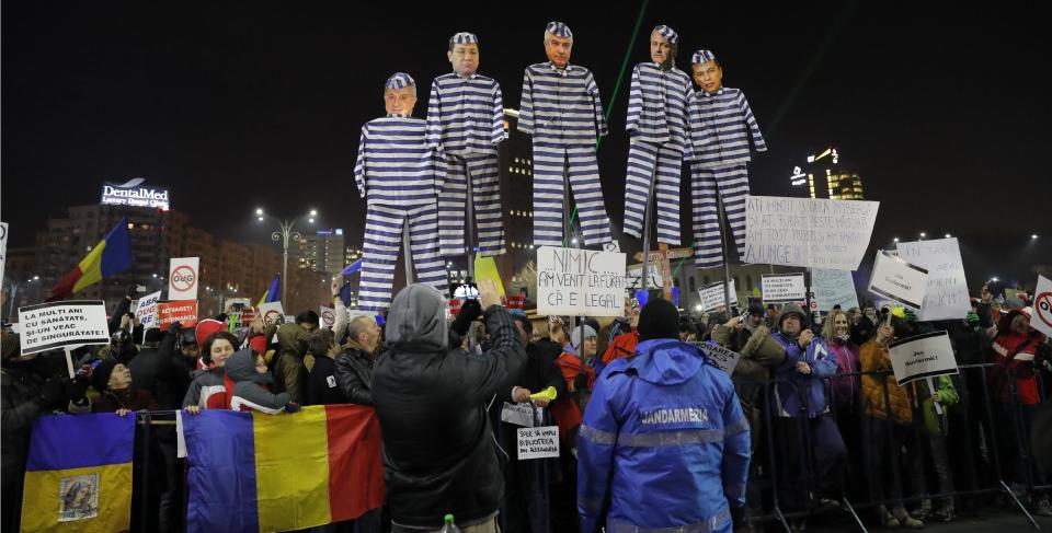 Demonstrators carry puppets depicting, left to right, Justice Minister Floring Lordache, former Prime Minister Victor Ponta, head of the senate Calin Popescu Tariceanu, leader of the social democratic party Liviu Dragnea, and Prime Minister Sorin Grindeanu during a protest in Bucharest, Romania, Friday, Feb. 3, 2017. Romania's political crisis is deepening over a government decree that may benefit rich and powerful people convicted of corruption. Central banner reads: "we came to steal because it is legal". (AP Photo/Vadim Ghirda)