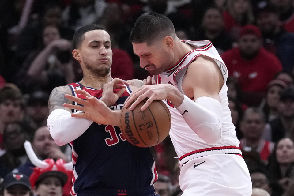 Chicago Bulls' Nikola Vucevic, right, drives to the basket as Washington Wizards' Kyle Kuzma defends during the second half of an NBA basketball game Wednesday, Dec. 7, 2022, in Chicago. The Bulls won 115-111. (AP Photo/Charles Rex Arbogast)