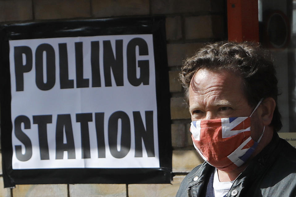 A man wearing a face covering leaves the polling station at St Albans Church after he voted, in London, Thursday, May 6, 2021. Millions of people across Britain will cast a ballot on Thursday, in local elections, the biggest set of votes since the 2019 general election. A Westminster special-election is also taking place in Hartlepool, England. (AP Photo/Frank Augstein)