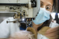 Workers of the Calzaturificio M.G.T shoe factory in Castelnuovo Vomano, central Italy, return to work, Monday, May 4, 2020. Italy began stirring again Monday after a two-month coronavirus shutdown, with 4.4 million Italians able to return to work and restrictions on movement eased in the first European country to lock down in a bid to stem COVID-19 infections. (AP Photo/Domenico Stinellis)