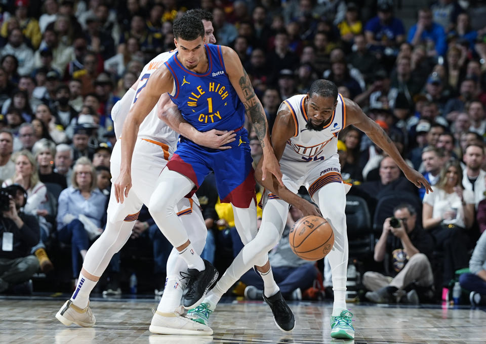 Denver Nuggets forward Michael Porter Jr., front left, knocks the ball away from Phoenix Suns forward Kevin Durant, right, while being held by Suns center Jusuf Nurkic during the second half of an NBA basketball game Tuesday, March 5, 2024, in Denver. (AP Photo/David Zalubowski)