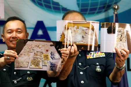 Police officers display photos of items from a raid during a news conference in Kuala Lumpur, Malaysia June 27, 2018. REUTERS/Lai Seng Sin