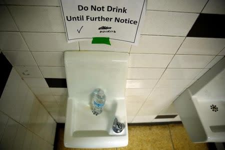 A sign is seen next to a water dispenser at North Western high school in Flint, a city struggling with the effects of lead-poisoned drinking water, in Michigan May 4, 2016. REUTERS/Carlos Barria