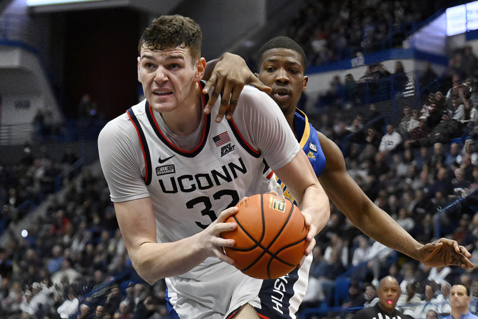 UConn center Donovan Clingan (32) drives to the basket as Xavier forward Abou Ousmane defends in the first half of an NCAA college basketball game, Sunday, Jan. 28, 2024, in Hartford, Conn. (AP Photo/Jessica Hill)