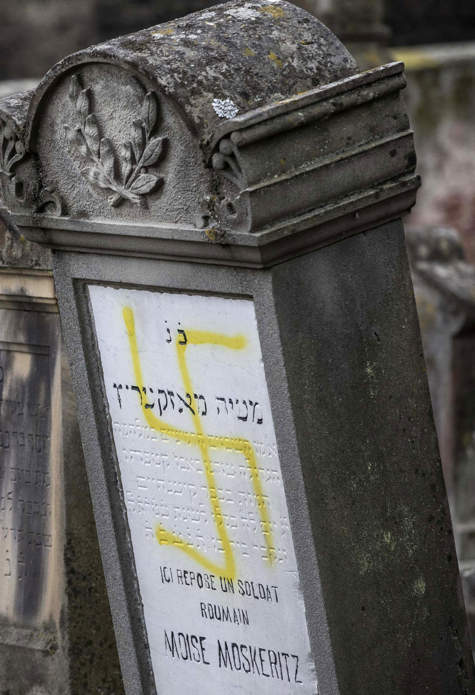 A vandalized tomb with tagged swastika is pictured in the Jewish cemetery of Quatzenheim, eastern France, Tuesday, Feb.19, 2019. Marches and gatherings against anti-Semitism are taking place across France following a series of anti-Semitic acts that shocked the country. (AP Photo/Jean-Francois Badias)