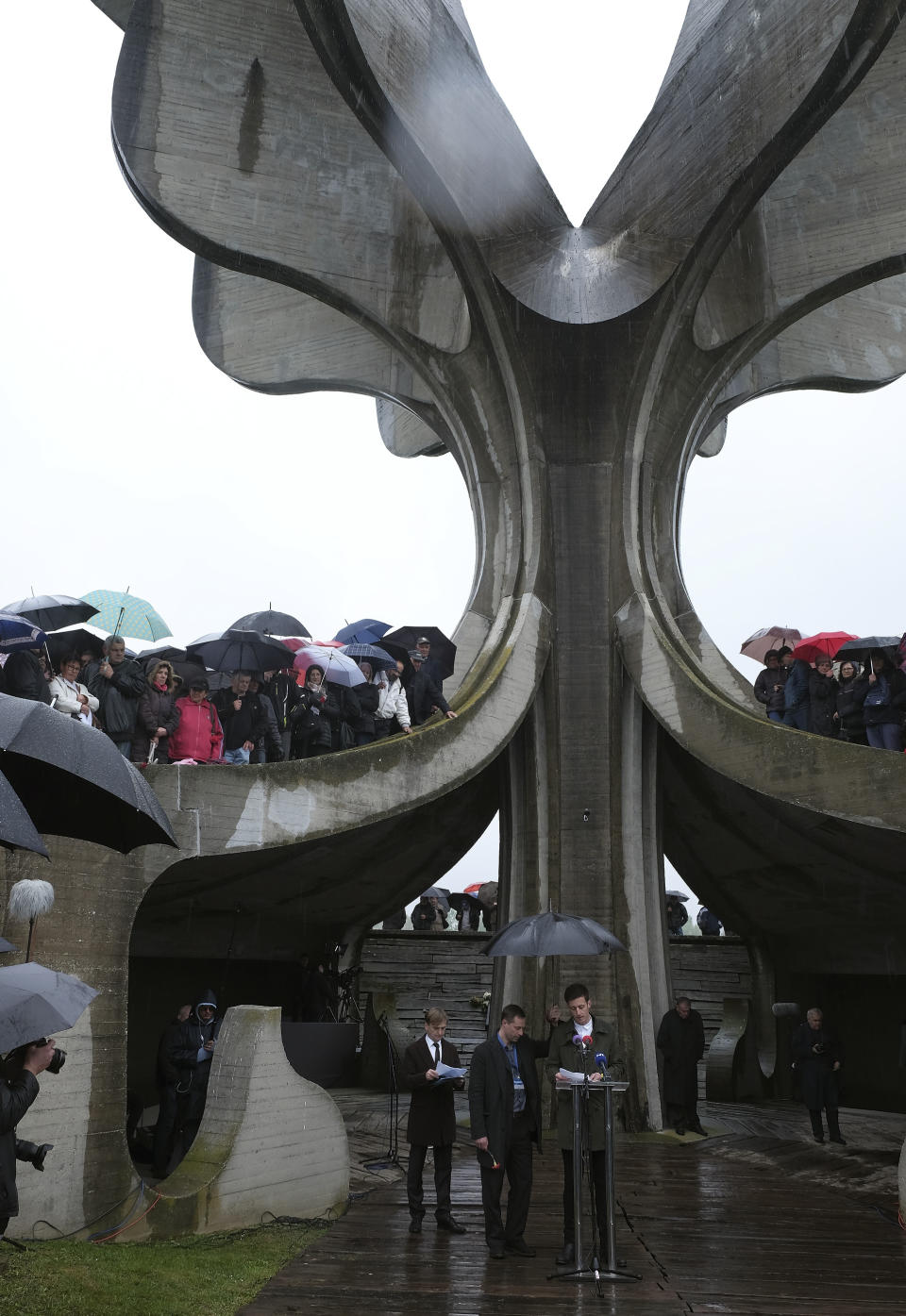 People gather at the monument for victims to pay their respects for tens of thousands of people killed in death camps run by Croatia's pro-Nazi puppet state in WWII, in Jasenovac, Croatia, Friday, April 12, 2019. Croatia's Jewish, Serb, anti-fascist and Roma groups have commemorated the victims of a World War II death camp, snubbing the official ceremonies for the fourth year in a row over what they say is government inaction to curb neo-Nazi sentiments in the European Union country. (AP Photo/Nikola Solic)