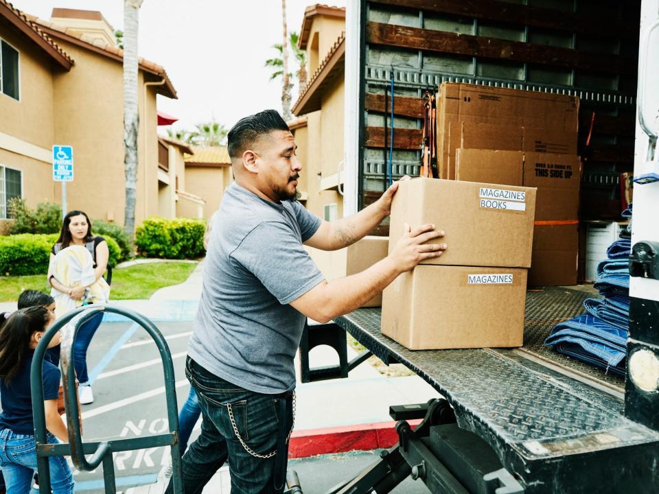 a man loads boxes into truck in moving van 