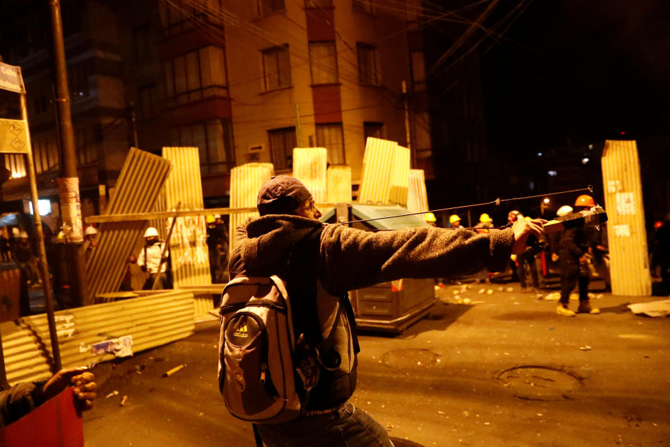 A protester against Bolivia's President Evo Morales uses a slingshot during clashes with government supporters in La Paz, Bolivia Nov. 7, 2019. (Photo: Kai Pfaffenbach/Reuters)