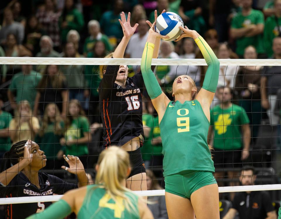 Oregon's Hannah Pukis, right, sets the ball against Oregon State's Lauren Rumel during the third set in Eugene Friday, Sept. 22, 2023.