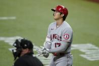 Umpire Sam Holbrook stands by the plate as Los Angeles Angels' Shohei Ohtani adjust his gloves during an at-bat in the first inning of a baseball game in Arlington, Texas, Tuesday, Sept. 28, 2021. (AP Photo/Tony Gutierrez)