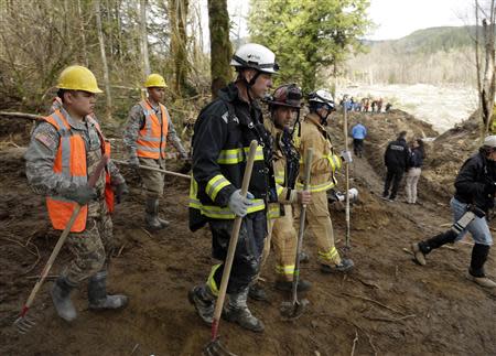 Workers carry shovels as search work continues in the mud and debris from a massive mudslide that struck Oso near Darrington, Washington April 2, 2014. REUTERS/Jason Redmond