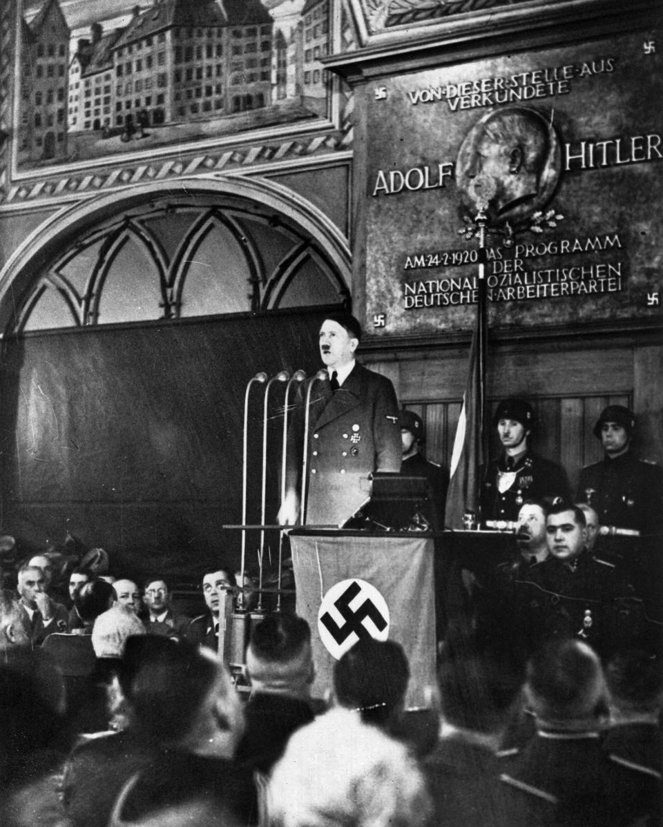 FILE - In this Feb. 24, 1940 file photo, Adolf Hitler delivers a surprise evening address at the historical Hofbreauhaus in Munich. A memorial plaque behind him commemorates the day he announced his national socialist program on the site 20 years earlier. (AP Photo)