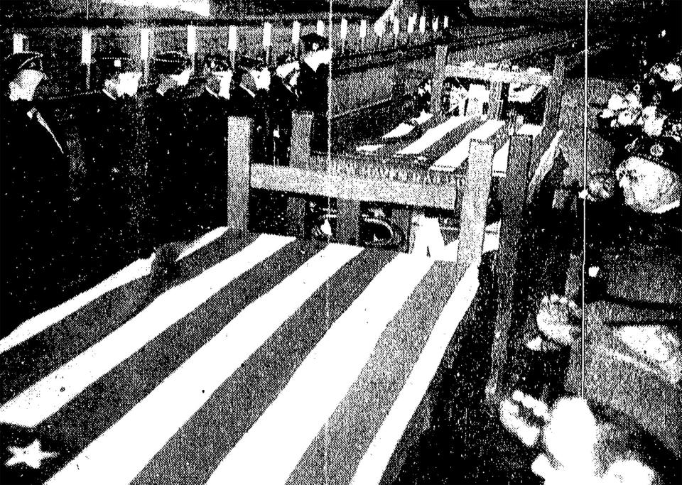 An honor guard of North Kingstown Legionnaires stands by on Feb. 6, 1952 as the flag-draped caskets of three fellow townsmen killed in action in Korea are moved down the platform after arriving at the Kingston station the day before.