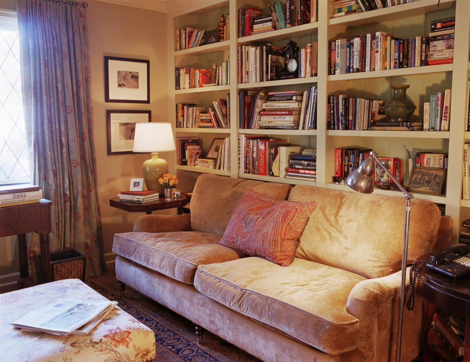 Built-in library shelves with a couch and lamps in front of it