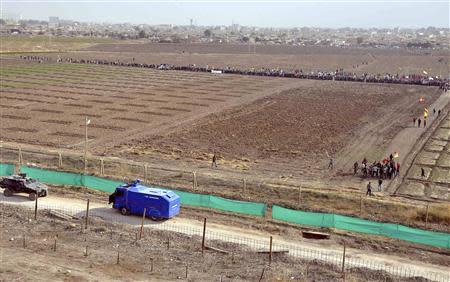 Syrian Kurds from the Syrian town of Qamishli gather behind border fences as Turkish troops stand guard (foreground) on the Turkish side of the border to prevent Turkish Kurdish protesters from approaching the fences in the southeastern town of Nusaybin November 7, 2013. REUTERS/Stringer