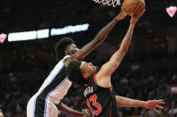 Toronto Raptors forward Jordan Nwora (13) drives to the basket under pressure from Orlando Magic forward Jonathan Isaac during the first half of an NBA basketball game Friday, March 15, 2024, in Toronto. (Frank Gunn/The Canadian Press via AP)