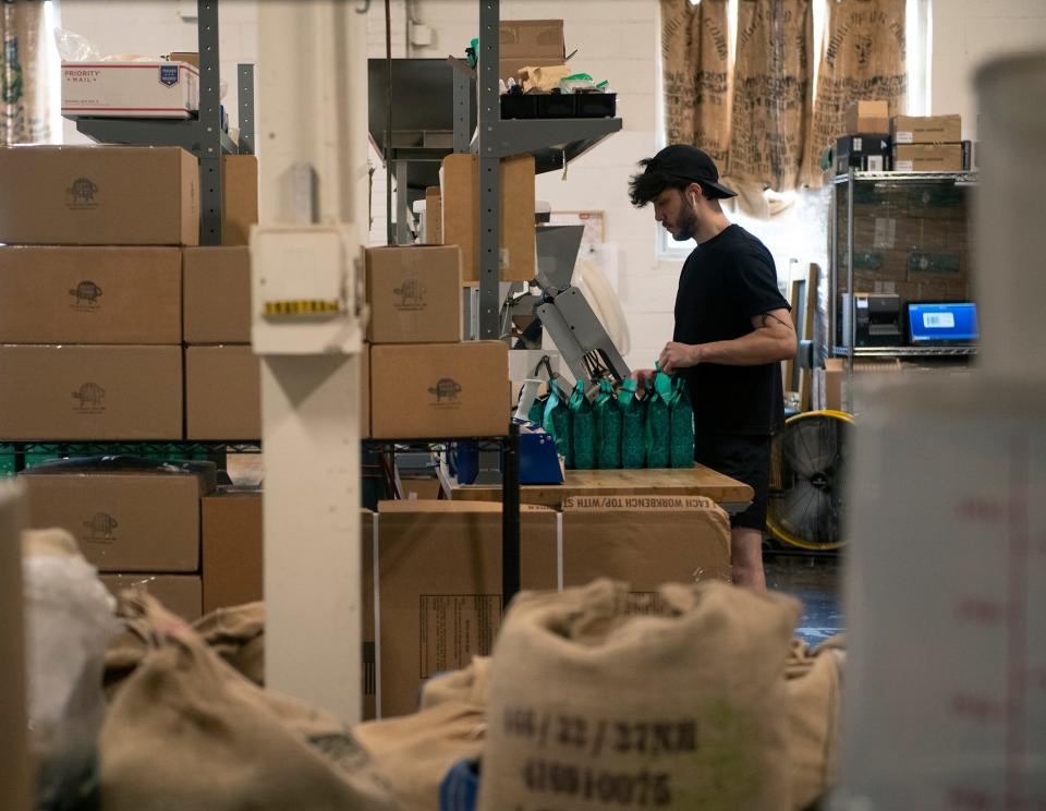 Adam Jimenez, production and delivery, fills and seals bags of beans at Bent Tree Coffee Roastery's production facility on Mogadore Road in Kent. The business is moving to a building on North Mantua Street, which is being renovated as a mixed use space.