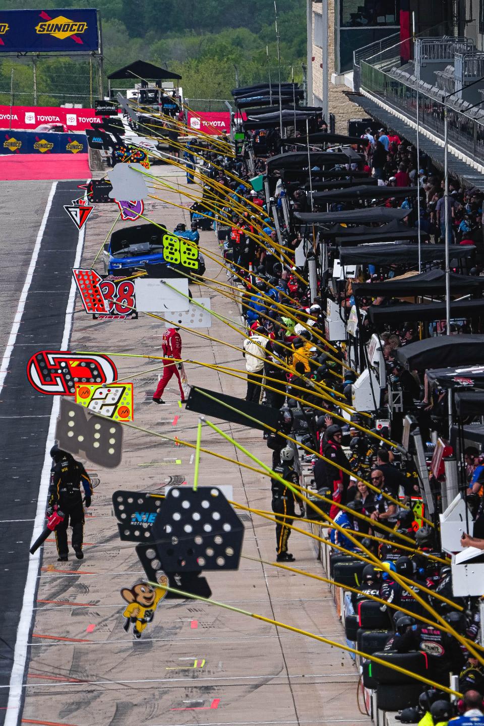 Numbers hang over the pit stalls of teams competing in the NASCAR Craftsman Truck Series Xpel 225 at Circuit of the Americas on Saturday.