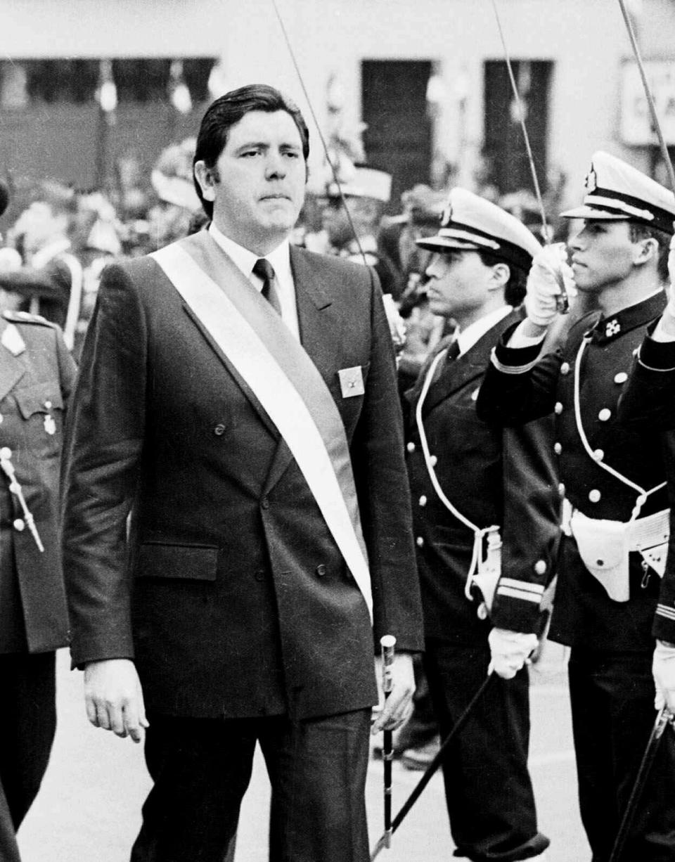 FILE - In this July 28, 1988 file photo, Peruvian President Alan García marches in front of palace guards at a military ceremony in Lima, Peru. Current Peruvian President Martinez Vizcarra said Garcia, the 69-year-old former head of state died Wednesday, April 17, 2019, after undergoing emergency surgery in Lima. Garcia shot himself in the head early Wednesday as police came to detain him in connection with a corruption probe. (AP Photo, File)