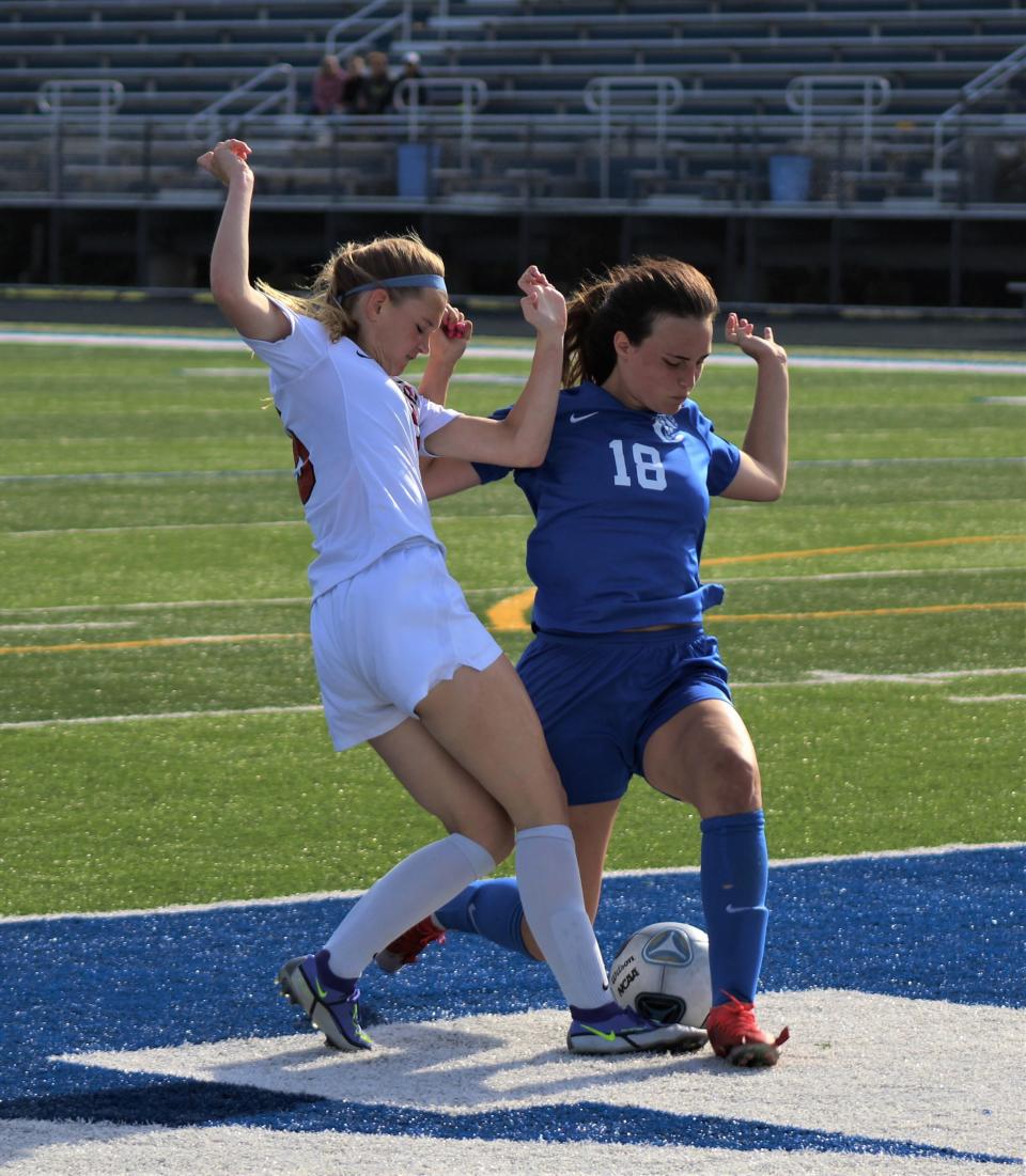 New Boston Huron's Rylie Cassette (left) and Carlson's Julia Ross battle for the ball during the Division 2 District opener Wednesday, May 25, 2022.