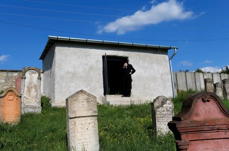 A rabbi stands in the door of a building that holds the tombs of rabbis at the Jewish cemetery in the village of Mad, Hungary, July 21, 2016. Picture taken July 21, 2016. REUTERS/Laszlo Balogh