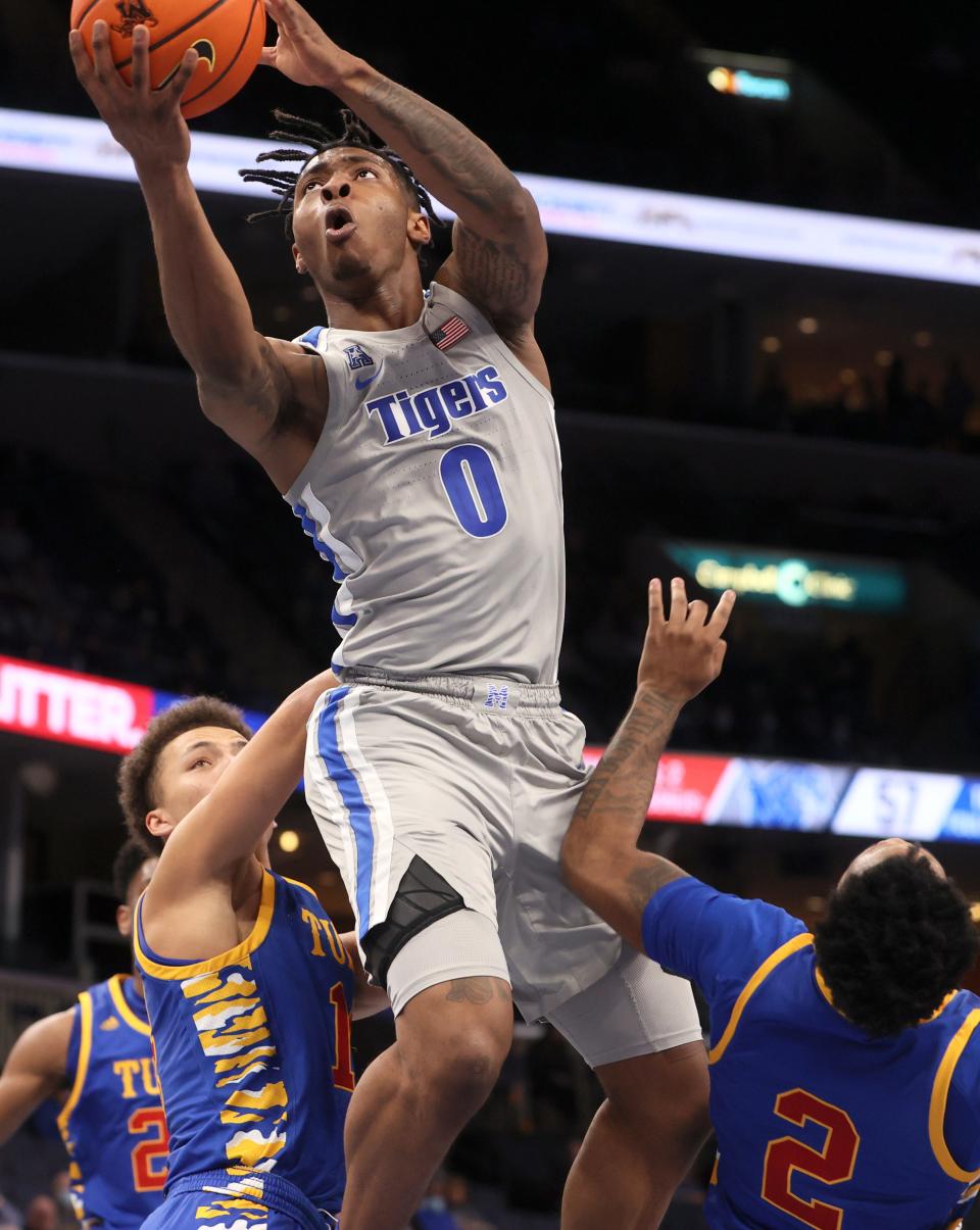 Memphis Tigers guard Earl Timberlake splits Tulsa Golden Hurricane defenders Anthony Pritchard (14) and Keyshawn Embery-Simpson (2) for a layup during their game at FedExForum on Tuesday, Jan. 4, 2022.