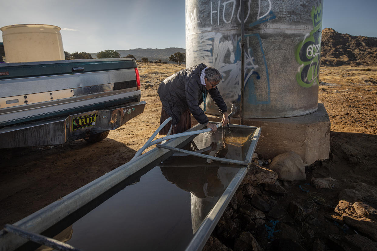  Marilyn Help-Hood prepares to fill up water jugs in Tolkakai, N.M., last week. (Sharon Chischilly for NBC News)