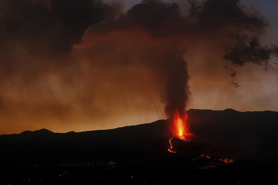 Lava flows from a volcano on the Canary island of La Palma, Spain in the early hours of Sunday Sept. 26, 2021. A volcano in Spain's Canary Islands is keeping nerves on edge several days since it erupted, producing loud explosions, a huge ash cloud and cracking open a new fissure that spewed out more fiery molten rock. (AP Photo/Daniel Roca)