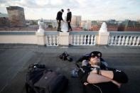 Yevgeny Halkechev of Rudex team rests as his team mates stand on the parapet of a roof in Moscow, Russia, May 13, 2017. REUTERS/Maxim Shemetov