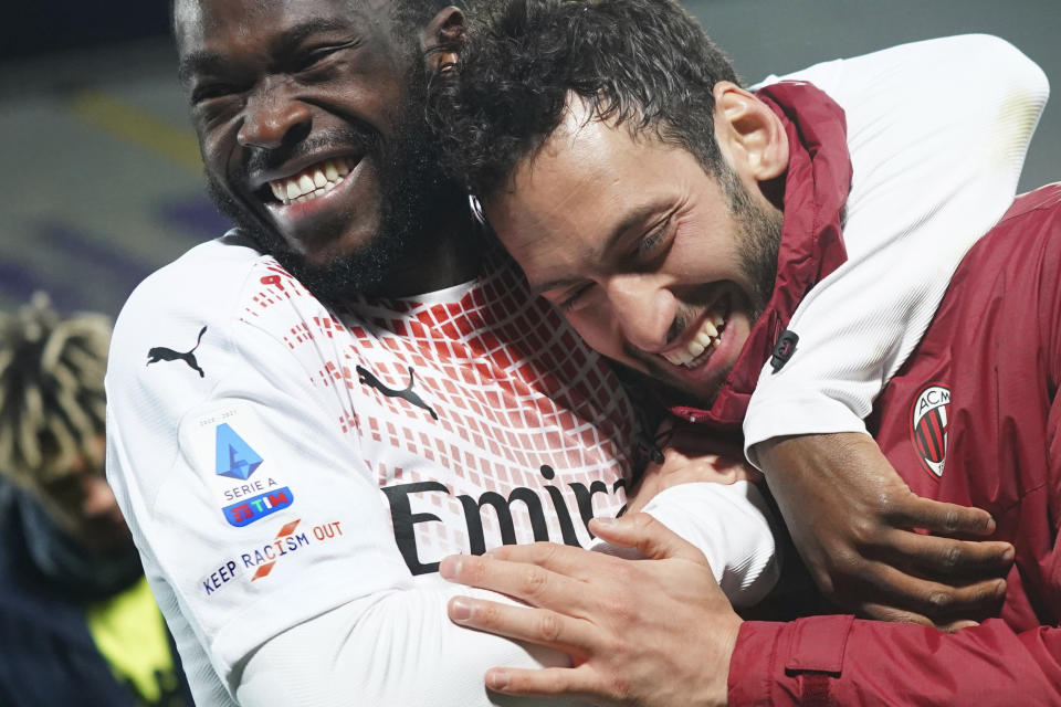 AC Milan's Fikayo Tomori, left, embraces teammate Hakan Calhanoglu as his jersey sports a badge reading "Keep racism out", part of the new anti-racism campaign launched last Sunday by the Italian soccer League, during a Serie A match between Fiorentina and AC Milan at the Artemio Franchi stadium in Florence, Italy, Sunday, March 21, 2021. Serie A’s efforts to combat racism inside its stadiums was in shambles little more than a year ago when league CEO Luigi De Siervo decided to take matters into his own hands. (Spada/LaPresse via AP)