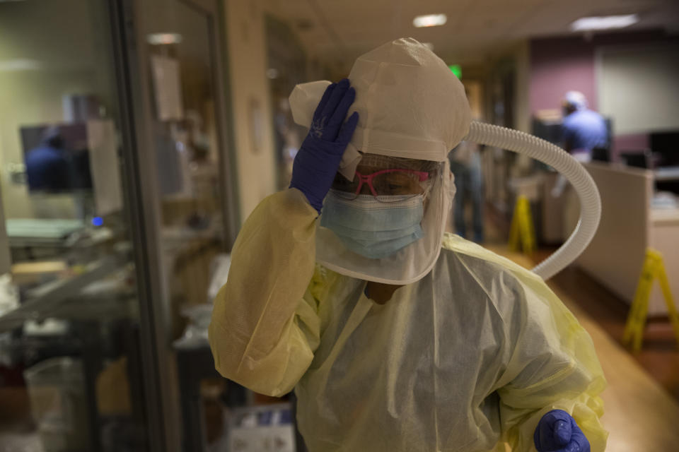 Nurse Shamaine Santos disinfects her respirator using bleach wipes after tending to a COVID-19 patient at St. Jude Medical Center in Fullerton, Calif., Tuesday, July 7, 2020. The pandemic rages on and cases climb throughout California, once again one of the nation's hot spots. The nurses forge ahead. They care for their patients during 12-hour shifts, taking temperatures and holding hands through gloves and wondering when, if, it will all end. (AP Photo/Jae C. Hong)