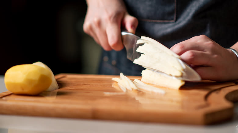 hands chopping potatoes