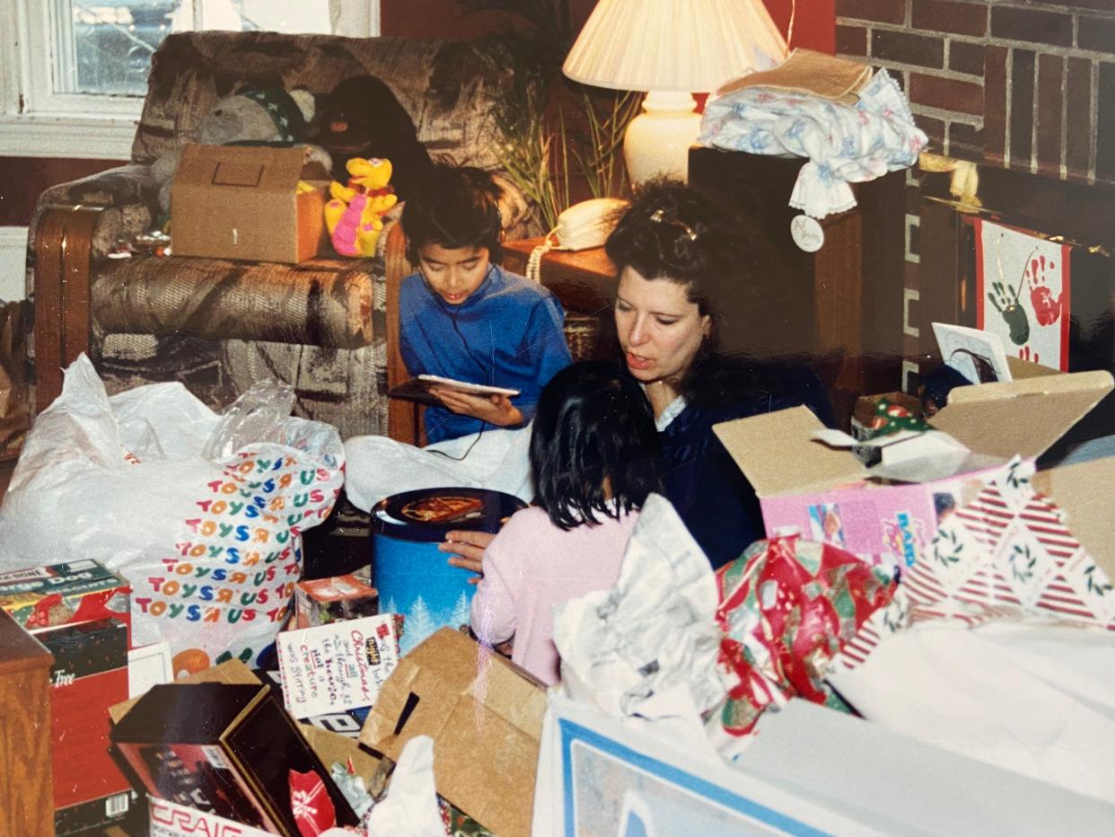 Susan Solomon Yem and two of her children opening gifts