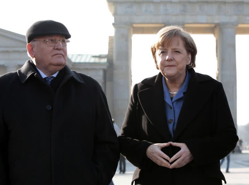 Former Soviet President Gorbachev and German Chancellor Merkel pose in front of Brandenburger Gate in Berlin