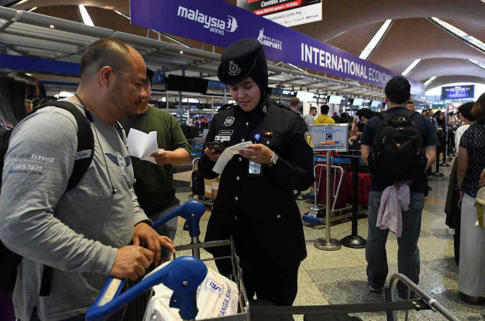 An policewoman assists a passenger at KLIA in Sepang August 23, 2019. — Bernama pic