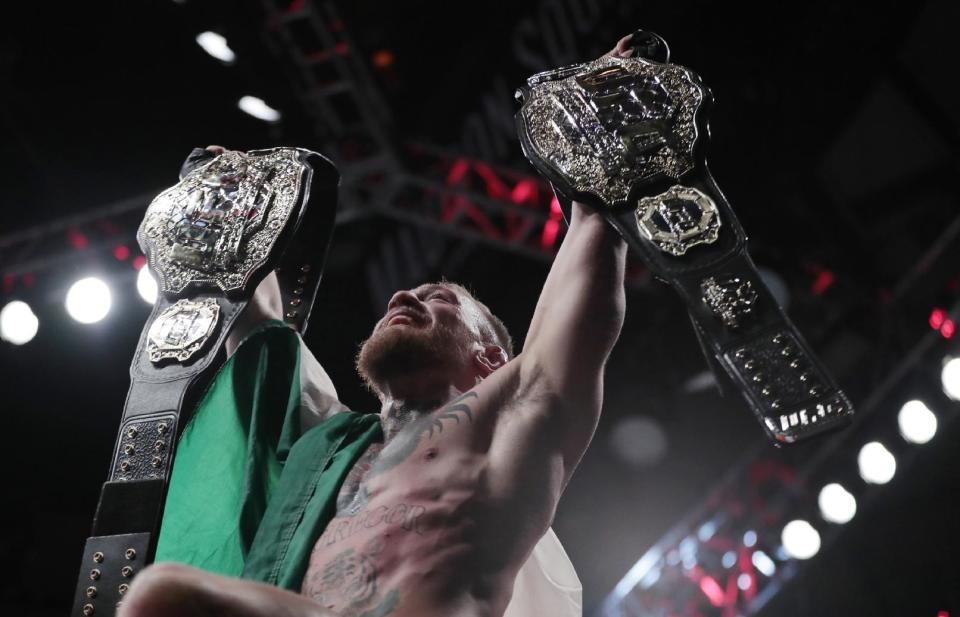 Conor McGregor holds up his title belts after he defeated Eddie Alvarez during a lightweight title mixed martial arts bout at UFC 205, at Madison Square Garden in New York. (AP Photo)