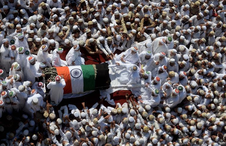 Indian Bohra Muslims gather around the coffin of their spiritual leader Syedna Mohammed Burhanuddin during his funeral procession in Mumbai on January 18, 2014