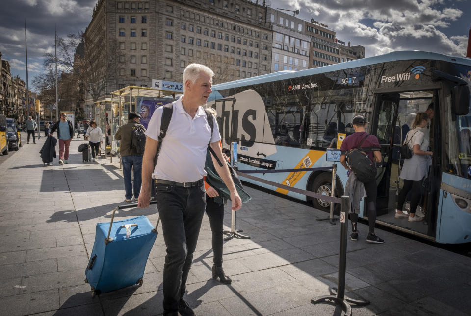 A tourist holding a suitcase heads to the AeroBus stop bound for Barcelona's Prat airport on March 1, 2020. (Paco Freire/SOPA Images/LightRocket via Getty Images)