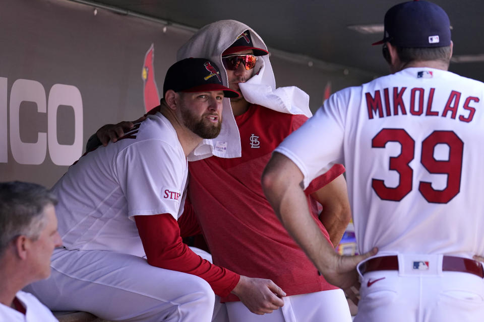 St. Louis Cardinals starting pitcher Jordan Montgomery, left, gets a hug from teammate Jack Flaherty as Miles Mikolas (39) watches after being removed during the seventh inning of a baseball game against the New York Yankees Sunday, July 2, 2023, in St. Louis. (AP Photo/Jeff Roberson)