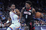 Houston Rockets forward Jae'Sean Tate (8) drives past Oklahoma City Thunder guard Shai Gilgeous-Alexander (2) in the first half of an NBA basketball game Wednesday, Dec. 1, 2021, in Oklahoma City. (AP Photo/Sue Ogrocki)