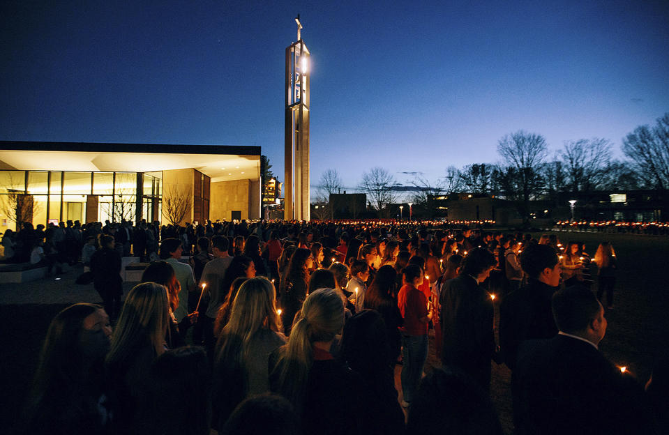 In this April 2, 2017 photo released by Sacred Heart University, students participate in a candlelight vigil in memory of student Caitlin Nelson on the school's campus in Fairfield, Conn. Police said Nelson, from Clark, N.J., died three days after choking during a pancake-eating contest at the college. (Sean Kaschak/Sacred Heart University via AP)