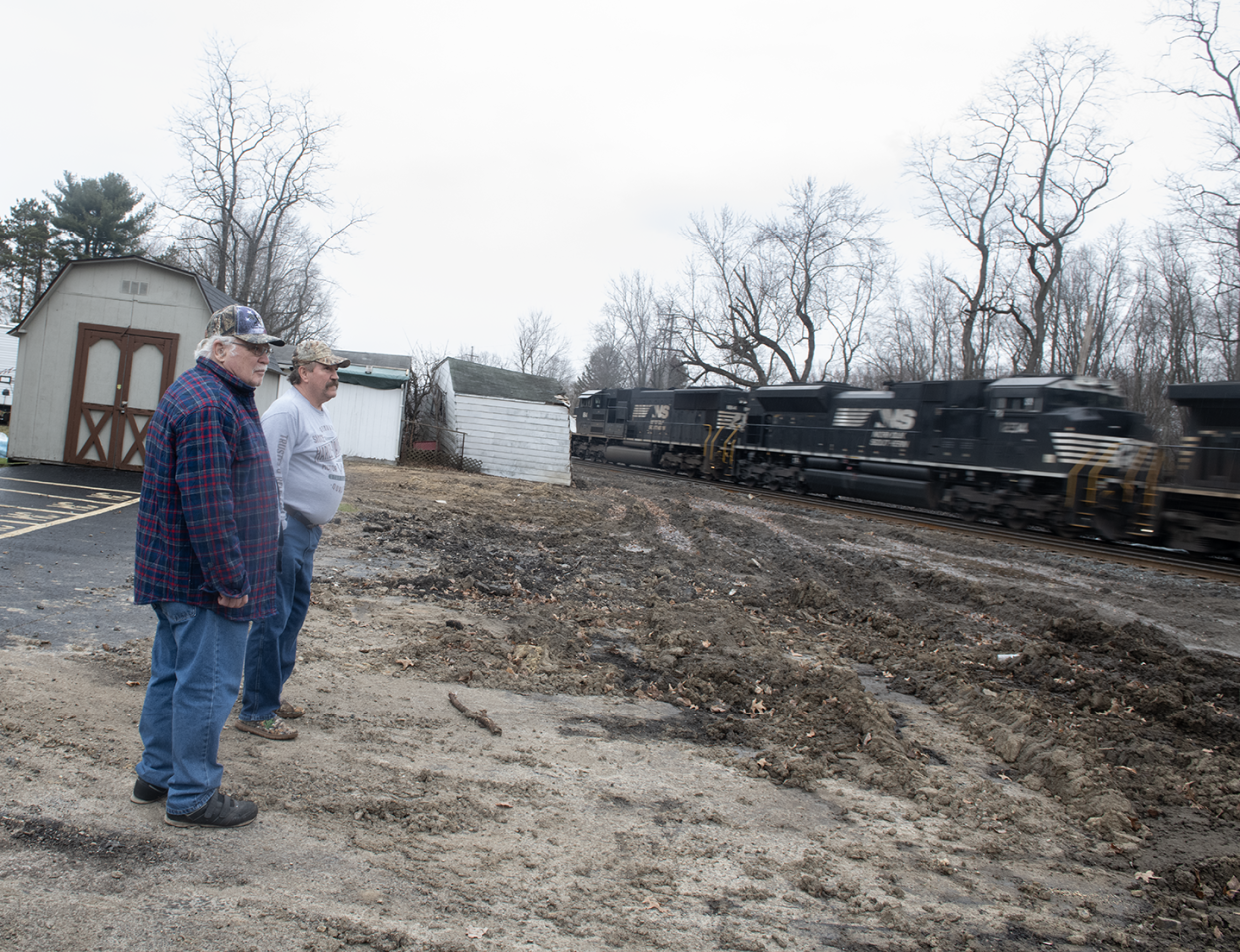 Property owner Bert McEwen of Ravenna Township and resident Chuck Knight, who witnessed a freight train derailment Nov. 1, watch last week as another train passes right next to the property.